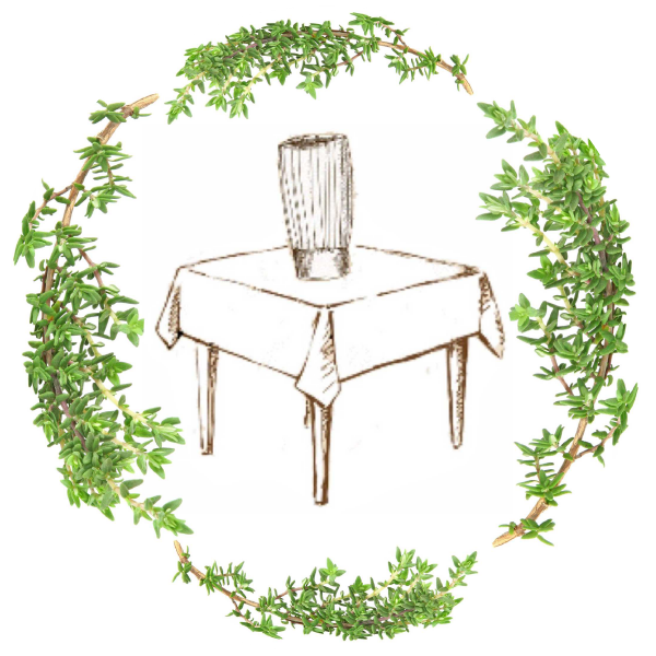 Table with vase surrounded by herbs