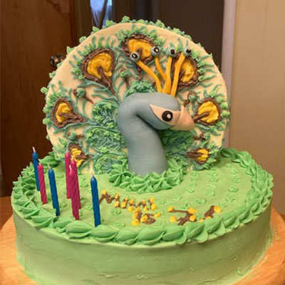 Peacock-themed birthday cake with candles