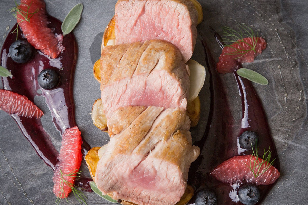 Sliced meat with berries and sauce